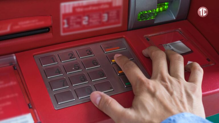 Mano presionando el botón "Cancelar" en un cajero automático rojo, ilustrando su función y precauciones de seguridad.